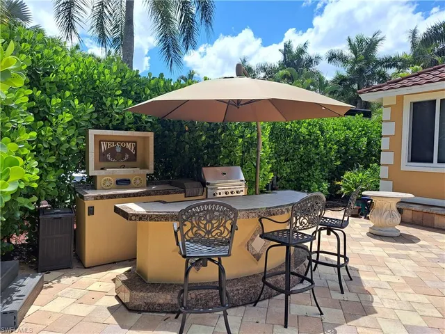 a patio with a table and chairs under an umbrella