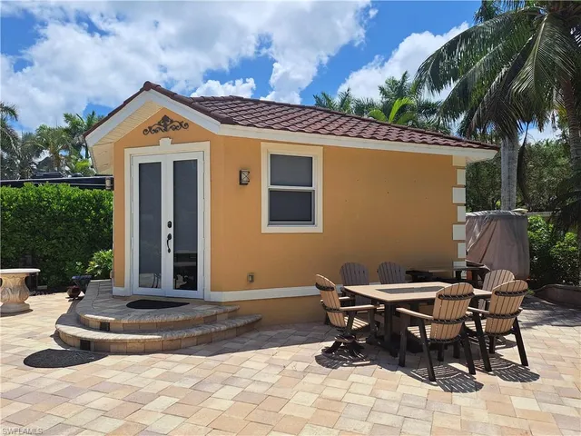 a view of a house with backyard and sitting area