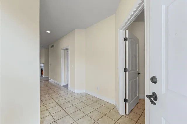 a view of a hallway with wooden floor and a bathroom