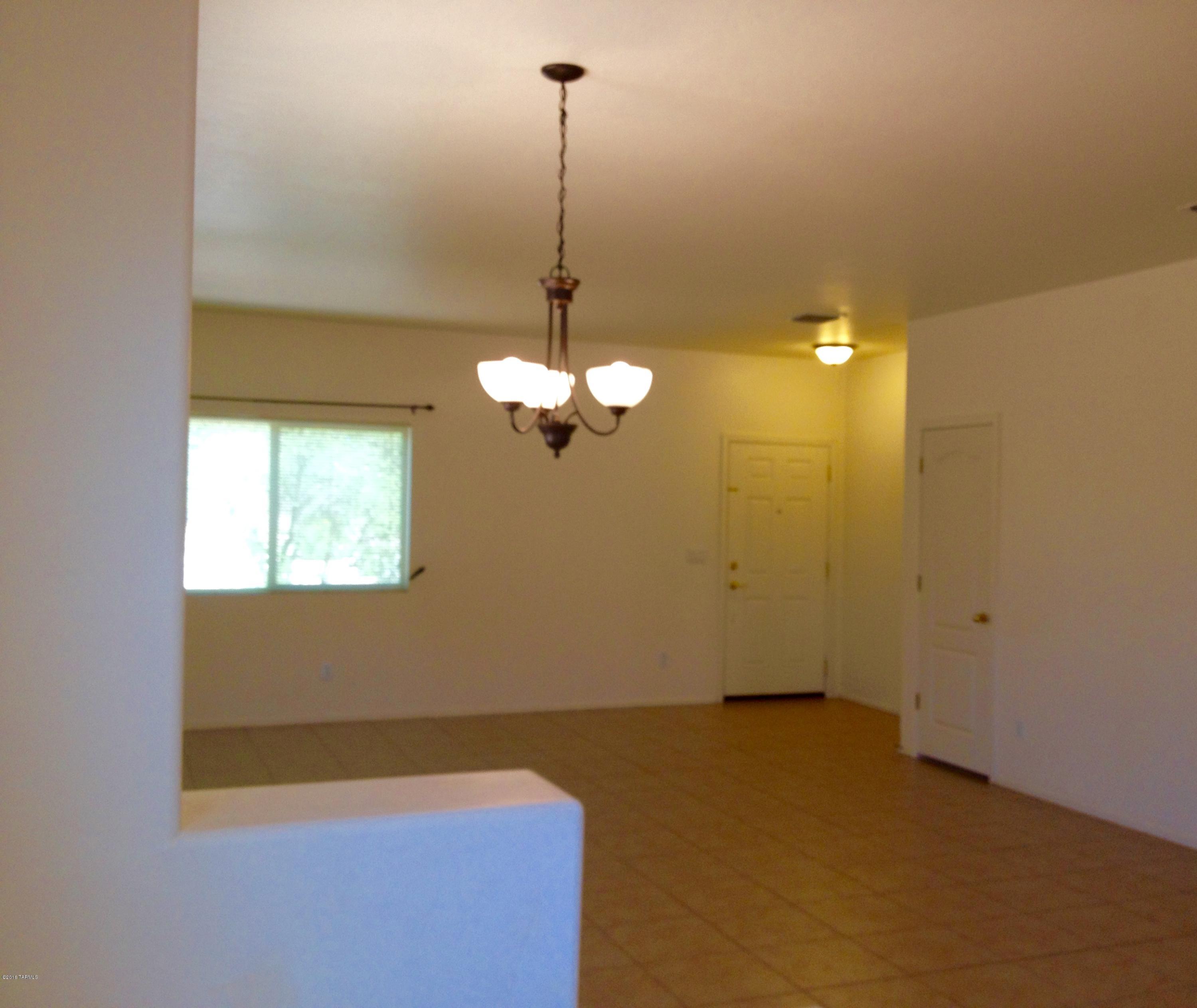 7931 North Iron Ridge Drive Tucson, AZ 85743 - Photo 4 of 21 a view of a room with a chandelier fan and windows