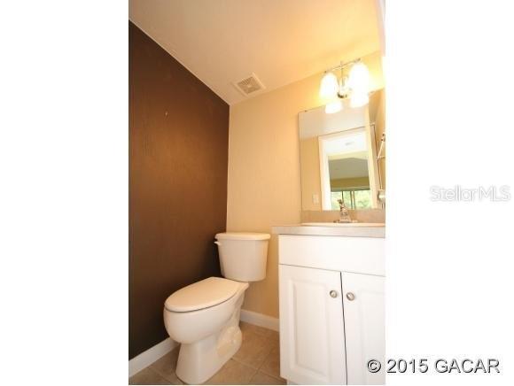 501 Southwest 75th Street, Unit J1 Gainesville, FL 32607 - Photo 7 of 12 a bathroom with a toilet a sink and a mirror