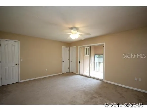 a view of an empty room and a ceiling fan