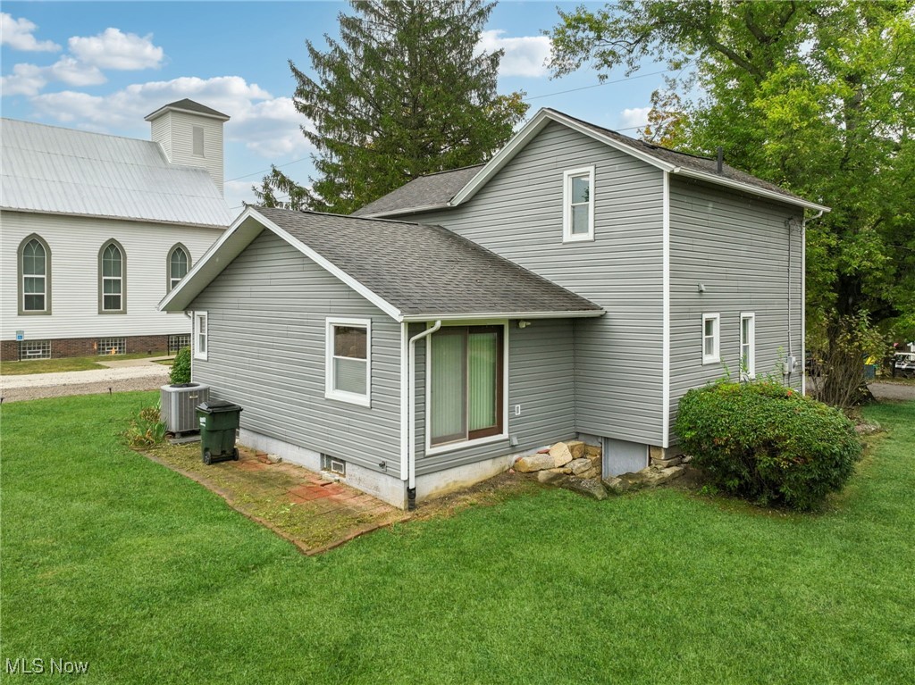 12422 Portage Street Rittman, OH 44270 - Photo 29 of 42 Rear view of house with a lawn and roof with shingles