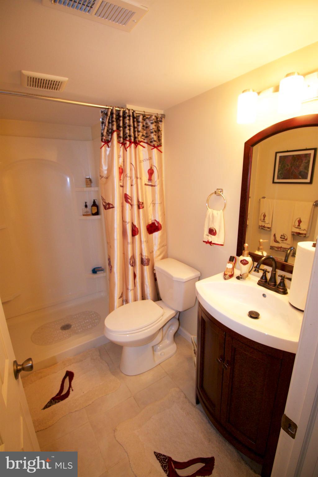 512 Old Riverside Road Baltimore, MD 21225 - Photo 31 of 38 a bathroom with a sink toilet mirror and shower