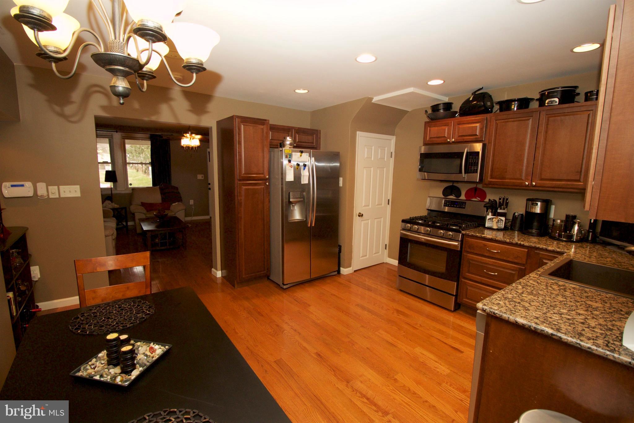 512 Old Riverside Road Baltimore, MD 21225 - Photo 10 of 38 a kitchen with stainless steel appliances kitchen island granite countertop a refrigerator a stove and a sink with granite countertops