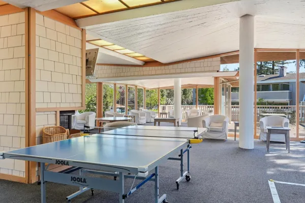 a dining room with furniture and large windows