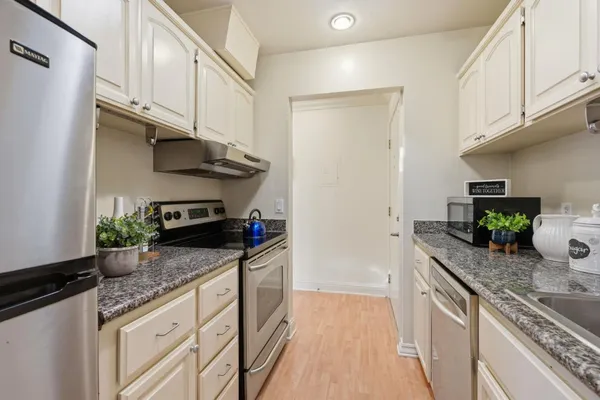 a kitchen with stainless steel appliances granite countertop a sink a stove and a refrigerator