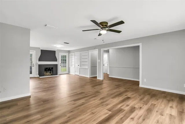 a view of an empty room with a fireplace and a window
