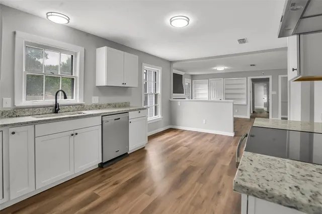 a kitchen with granite countertop a sink stove and refrigerator