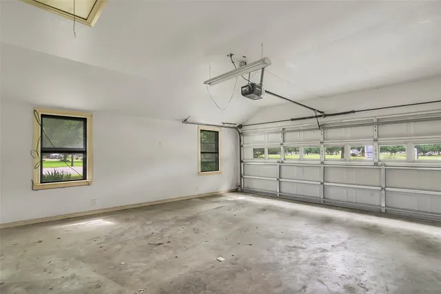 an empty room with wooden floor fireplace and windows