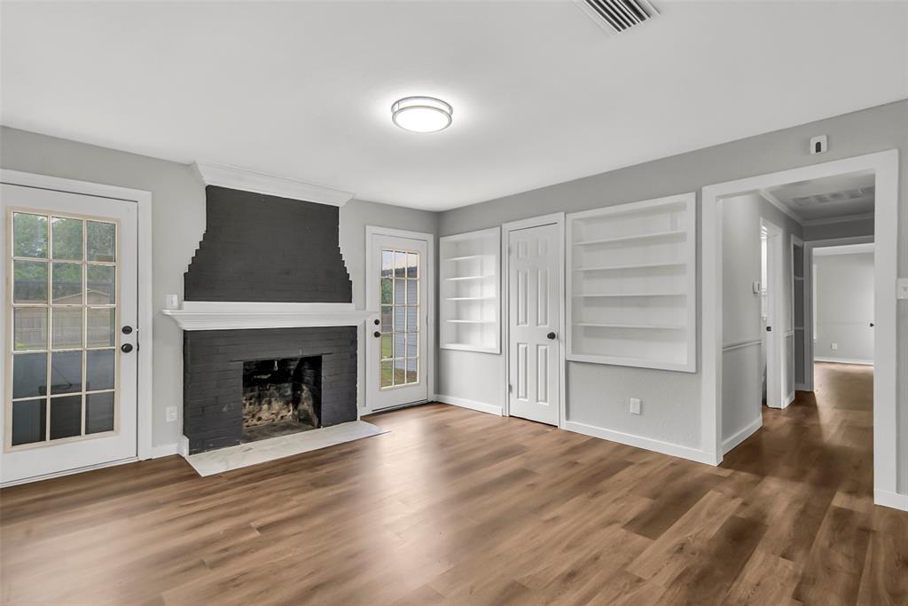 820 Lipscomb Street Bonham, TX 75418 - Photo 18 of 31 an empty room with wooden floor fireplace and windows