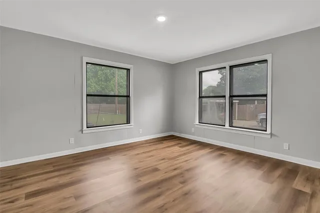 a view of an empty room with wooden floor