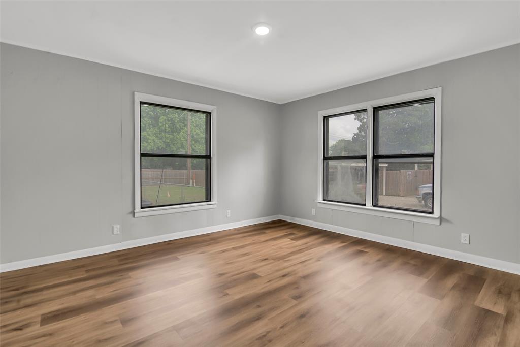 820 Lipscomb Street Bonham, TX 75418 - Photo 25 of 31 an empty room with wooden floor and windows