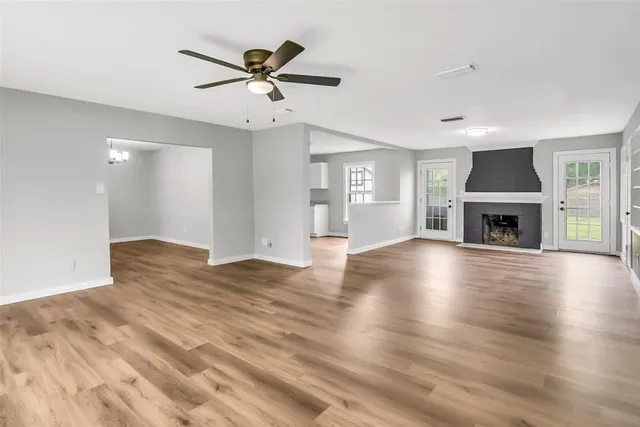 a view of empty room with wooden floor and fireplace