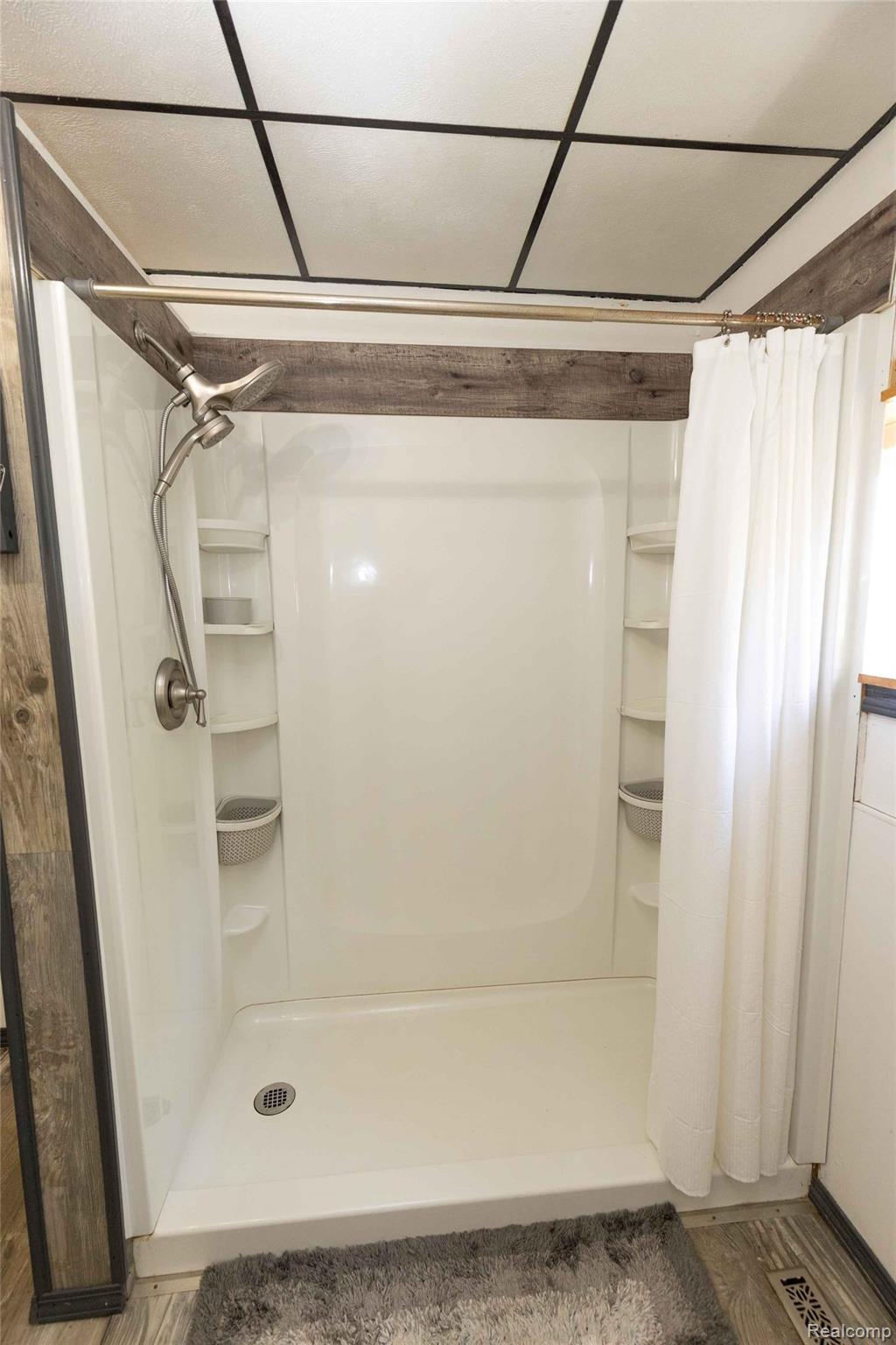 5761 Genesee Road Lapeer, MI 48446 - Photo 24 of 52 White shower stall with integrated shelving and a brushed nickel showerhead