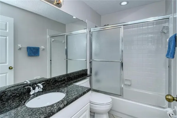 a bathroom with a granite countertop sink toilet and shower