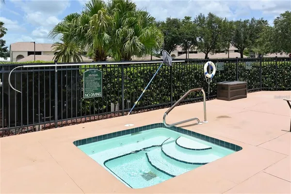 a view of a swimming pool with a patio and plants
