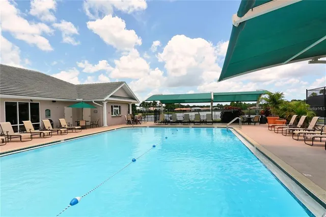 a view of a swimming pool with couches chairs and a table