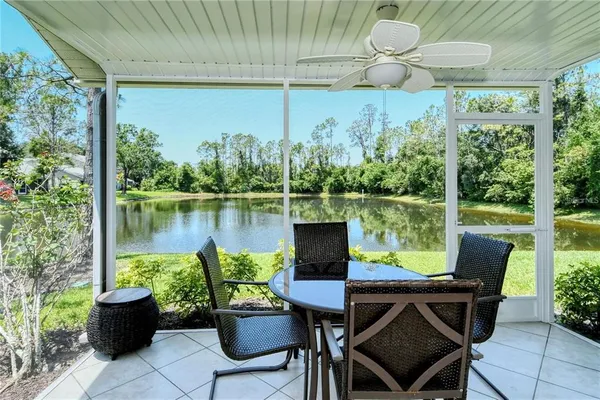 a view of a chairs and table in patio with a lake view