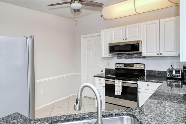 a kitchen with stainless steel appliances a stove a microwave and sink