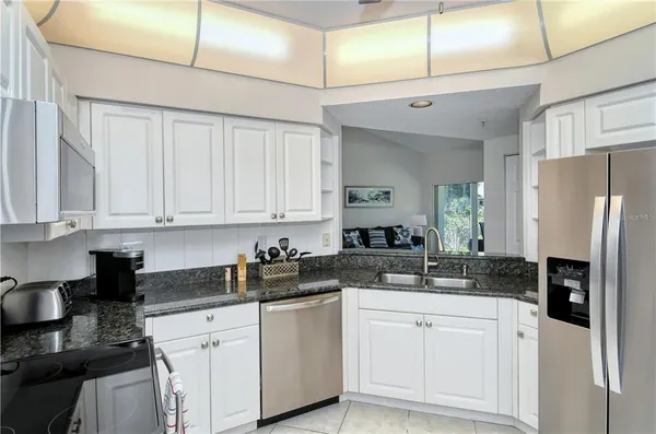 a kitchen with white cabinets and refrigerator
