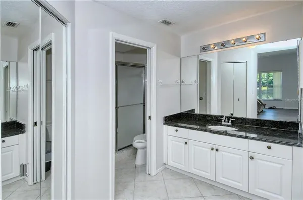 a bathroom with a granite countertop sink and a mirror