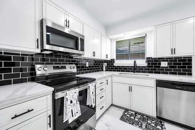 a kitchen with stainless steel appliances granite countertop a refrigerator and a stove top oven