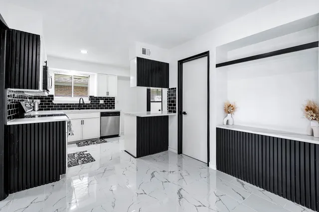 a kitchen with stainless steel appliances a stove a sink a microwave and cabinets