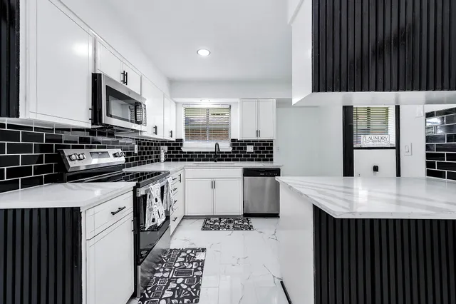 a kitchen with stainless steel appliances kitchen island granite countertop a sink and cabinets