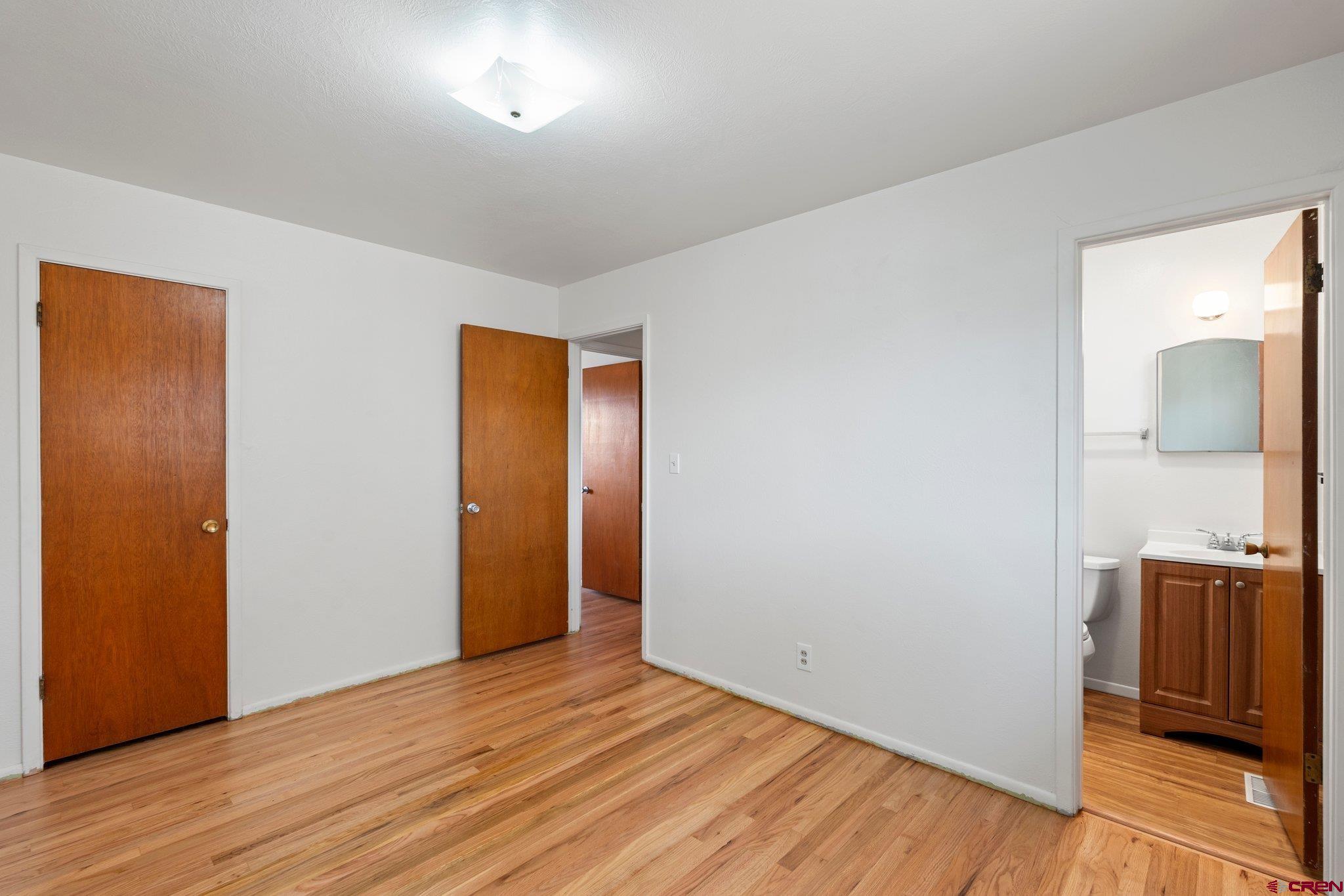 906 Edith Street Cortez, CO 81321 - Photo 18 of 33 an empty room with wooden floor and mirror