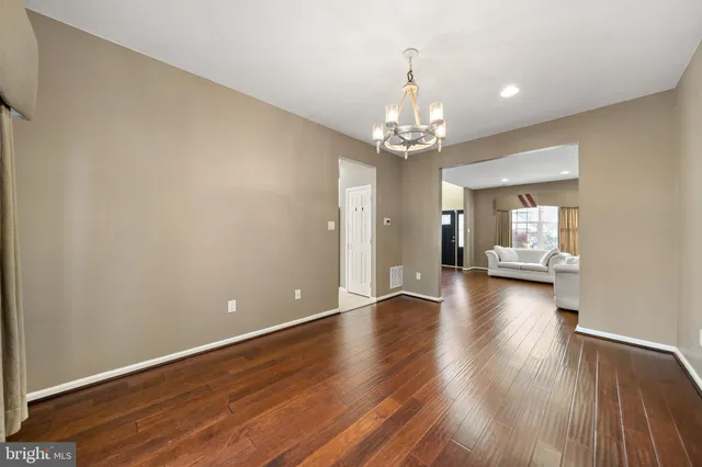 a view of a livingroom with wooden floor and a kitchen space