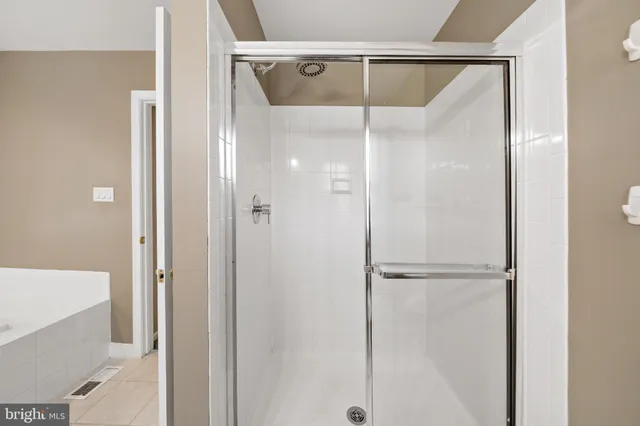 a bathroom with a glass shower door and a bathtub
