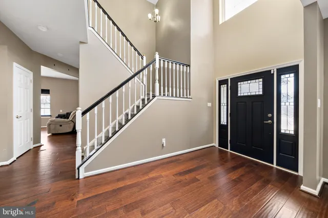 a view of a hallway with wooden floor and stairs