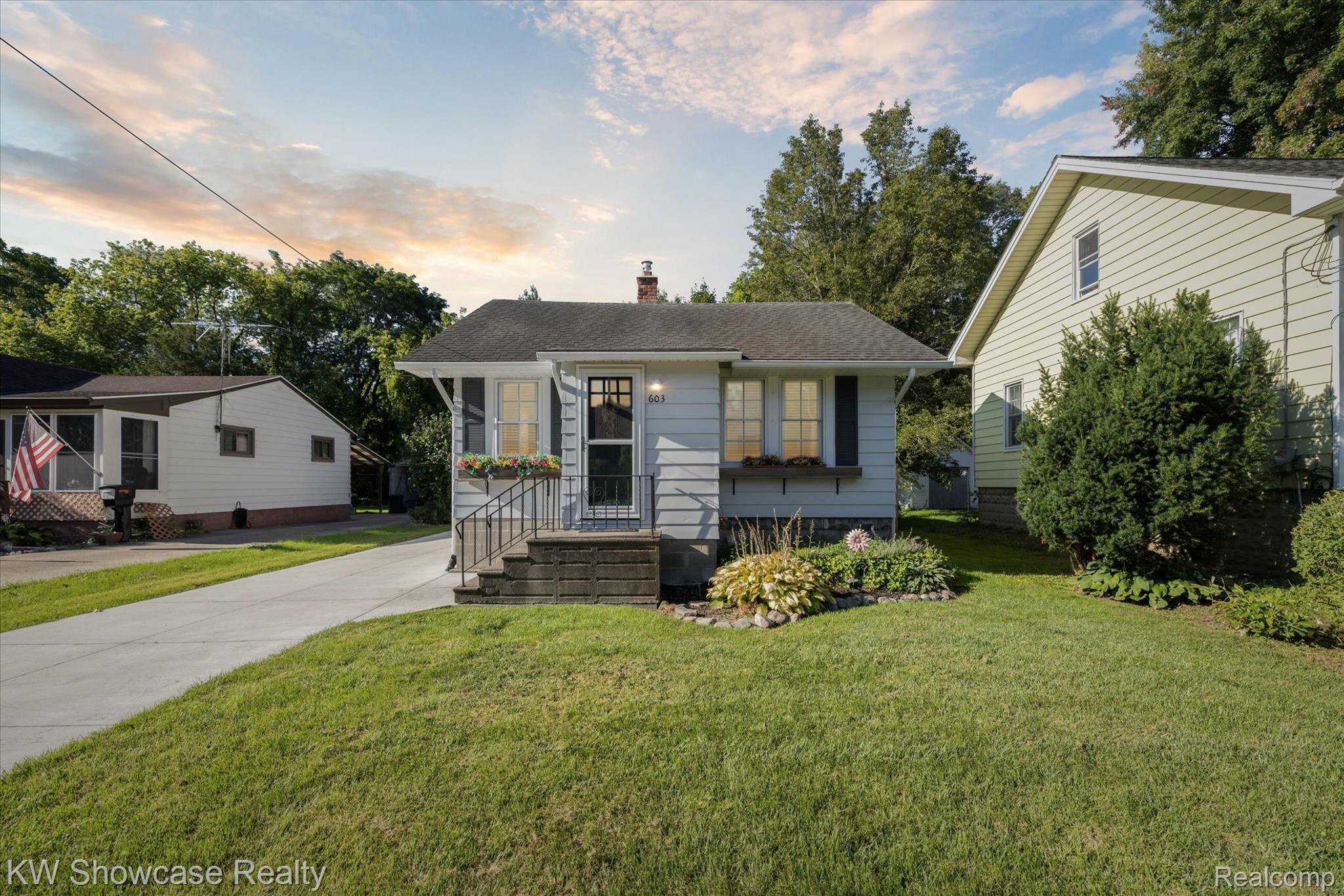 603 West Clinton Street Howell, MI 48843 - Photo 1 of 25 Bungalow-style home with a lawn, a chimney, concrete driveway, and a shingled roof
