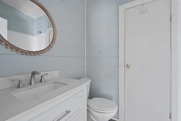 a bathroom with a sink a toilet and a mirror