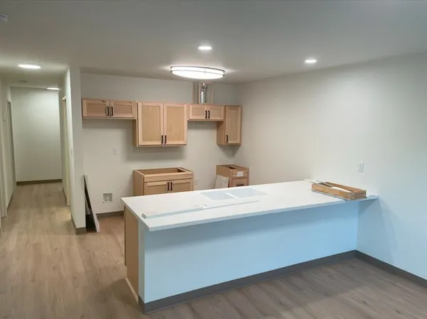 a utility room with stainless steel appliances a wooden floor