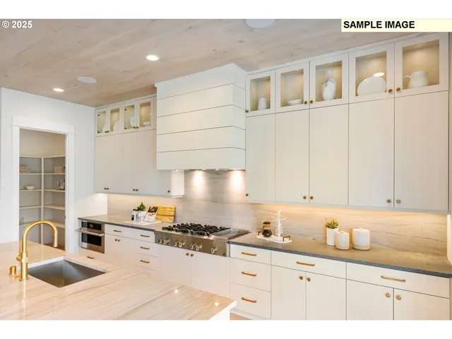 a kitchen with granite countertop a sink a stove and cabinets
