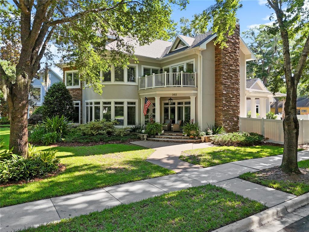 a front view of a house with a yard and trees