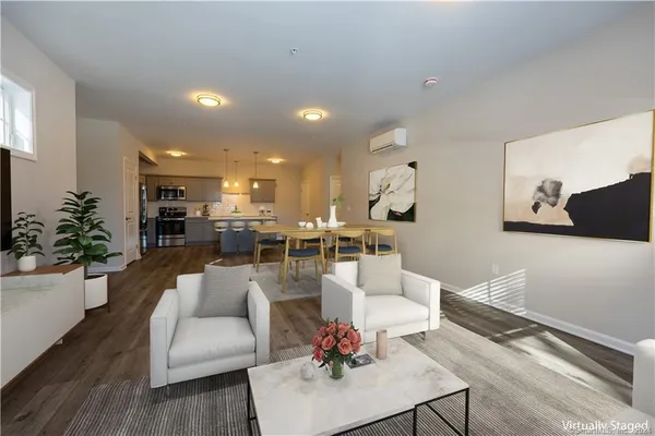 a living room with furniture kitchen view and a potted plant