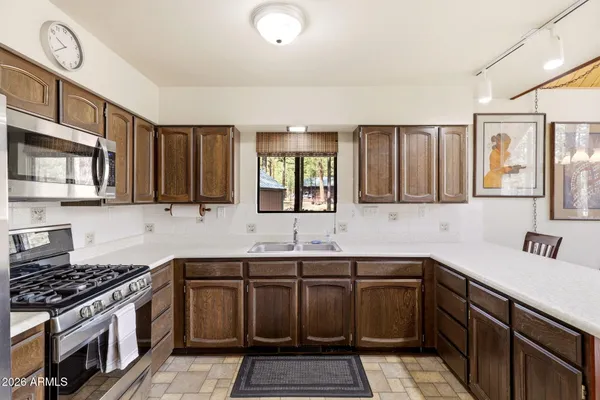 a kitchen with a sink stove top oven and cabinets