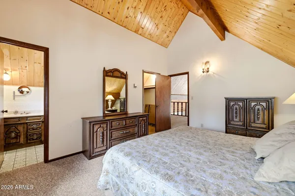 a bedroom with a bed and dresser with mirror