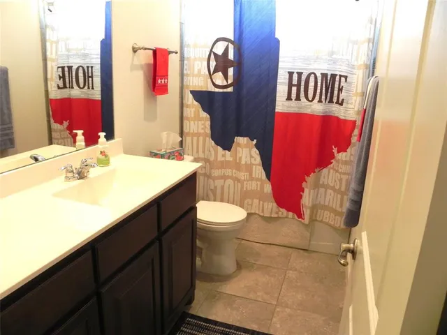 a bathroom with a sink vanity mirror and toilet