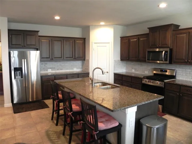a kitchen with a table chairs and refrigerator