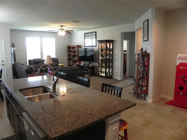 a kitchen with granite countertop a sink a counter top space and stainless steel appliances