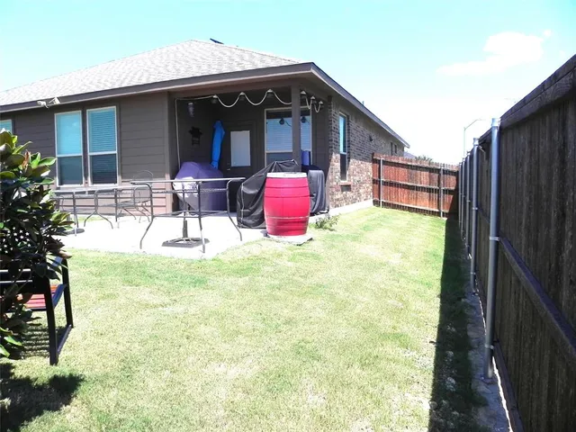 a backyard of a house with table and chairs