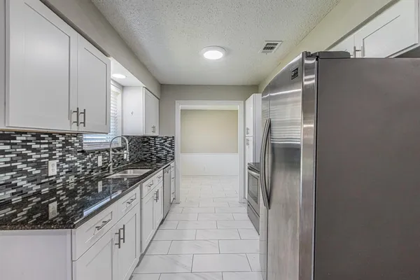 a bathroom with a sink vanity granite and a mirror