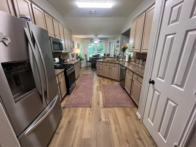 a kitchen with stainless steel appliances a refrigerator a stove a sink and a refrigerator