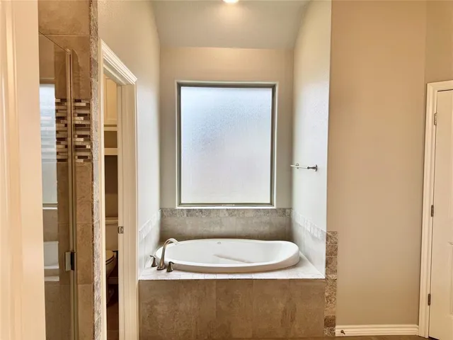 a bathroom with a bathtub and a window