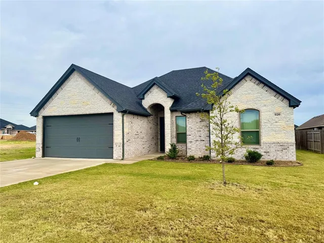 a front view of a house with yard and garage