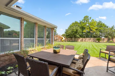 a view of a patio with a table chairs and a backyard